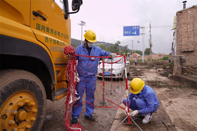 應(yīng)急保電人員正在為電源車裝設(shè)網(wǎng)圍欄。王國棟攝