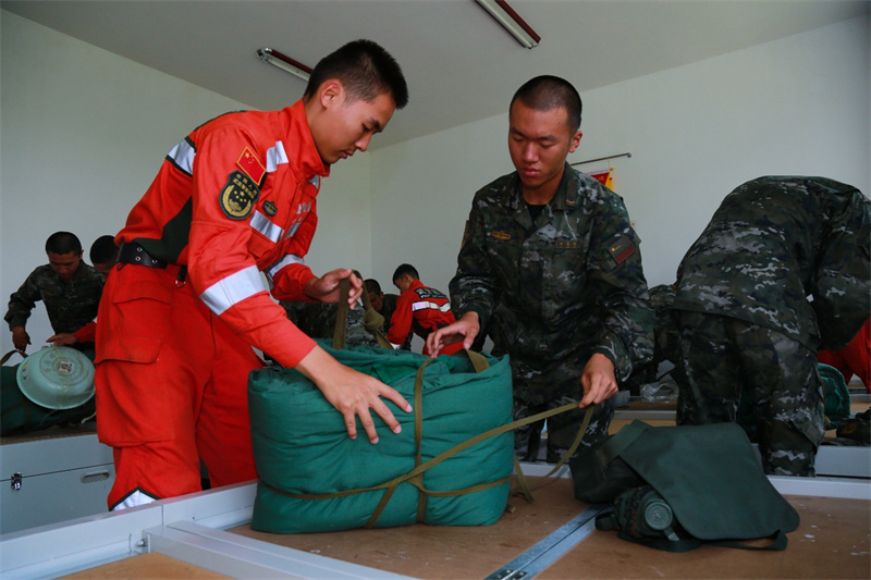 老兵幫新兵整理床鋪。羅元凱攝