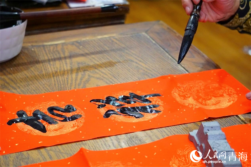 義寫春聯(lián)。人民網(wǎng) 況玉攝