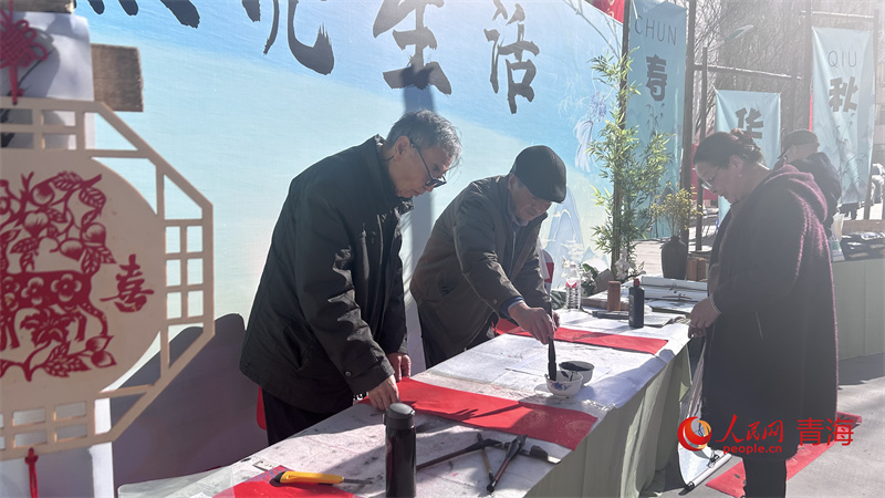 老人現(xiàn)場(chǎng)揮墨寫對(duì)聯(lián)。人民網(wǎng) 陳明菊攝