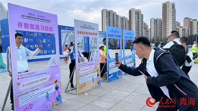 市民打卡城西區(qū)半程馬拉松賽。人民網(wǎng) 陳明菊攝