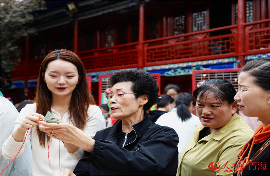 市民學(xué)習(xí)包粽子。人民網(wǎng) 顧斐菲攝