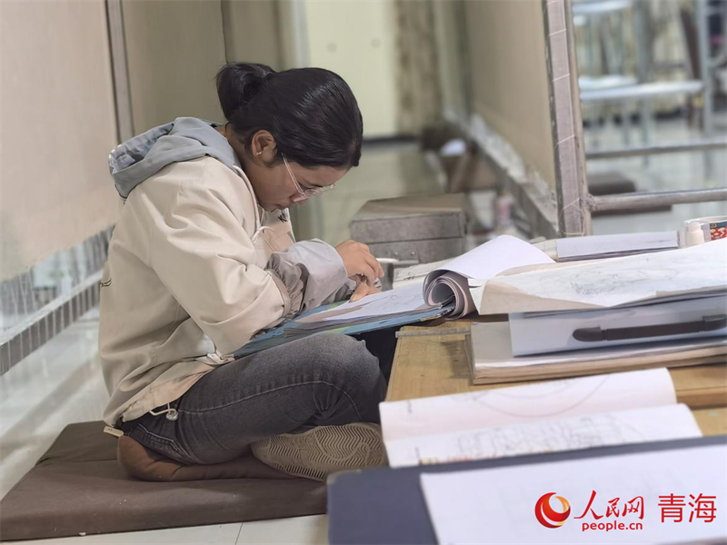 正在學(xué)習(xí)畫底稿的尕讓旺姆。人民網(wǎng) 陳明菊攝