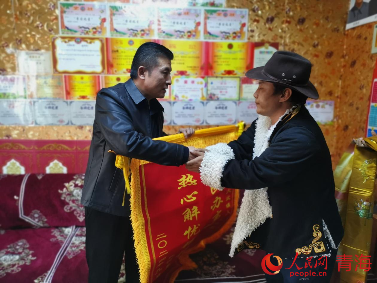 扎西東智(右)為董暉(左)送上錦旗。人民網(wǎng) 況玉攝