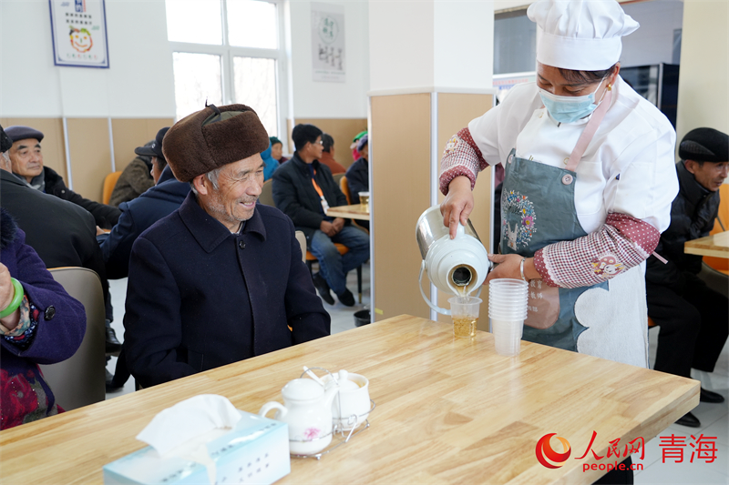 工作人員為老人倒水。人民網(wǎng) 況玉攝