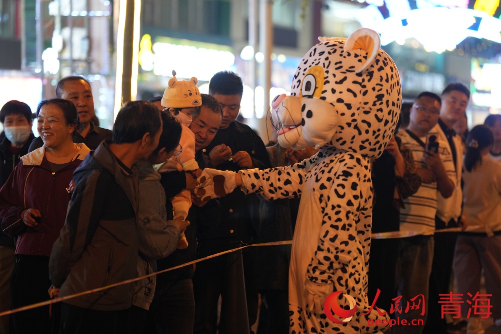 雪豹人偶與市民互動。人民網 況玉攝