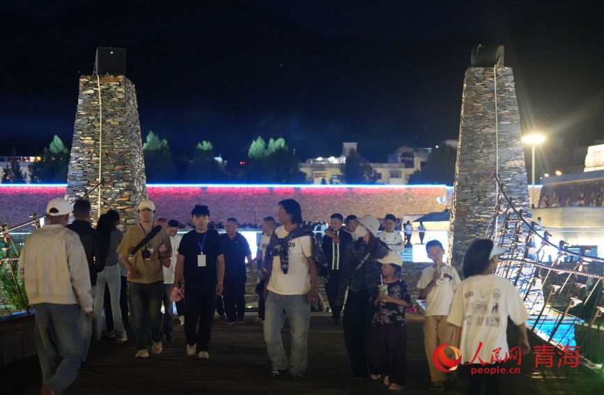 游客在玉樹巴塘河畔步行街。人民網(wǎng)記者 甘海瓊攝