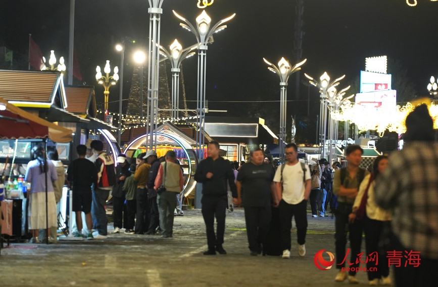 游客在玉樹巴塘河畔步行街。人民網(wǎng)記者 甘海瓊攝