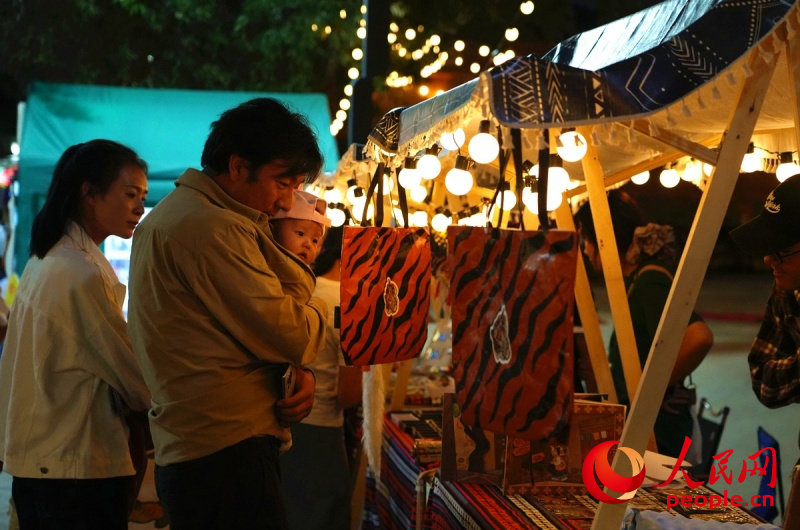 游客在同仁唐卡小鎮(zhèn)文創(chuàng)攤位前駐足。人民網(wǎng)記者 楊啟紅攝