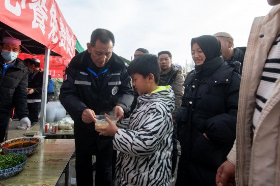 12月20日，在甘肅省臨夏州積石山縣大河家鎮(zhèn)大河村集中安置點(diǎn)，小朋友領(lǐng)取愛心牛肉面。人民網(wǎng)記者 翁奇羽攝